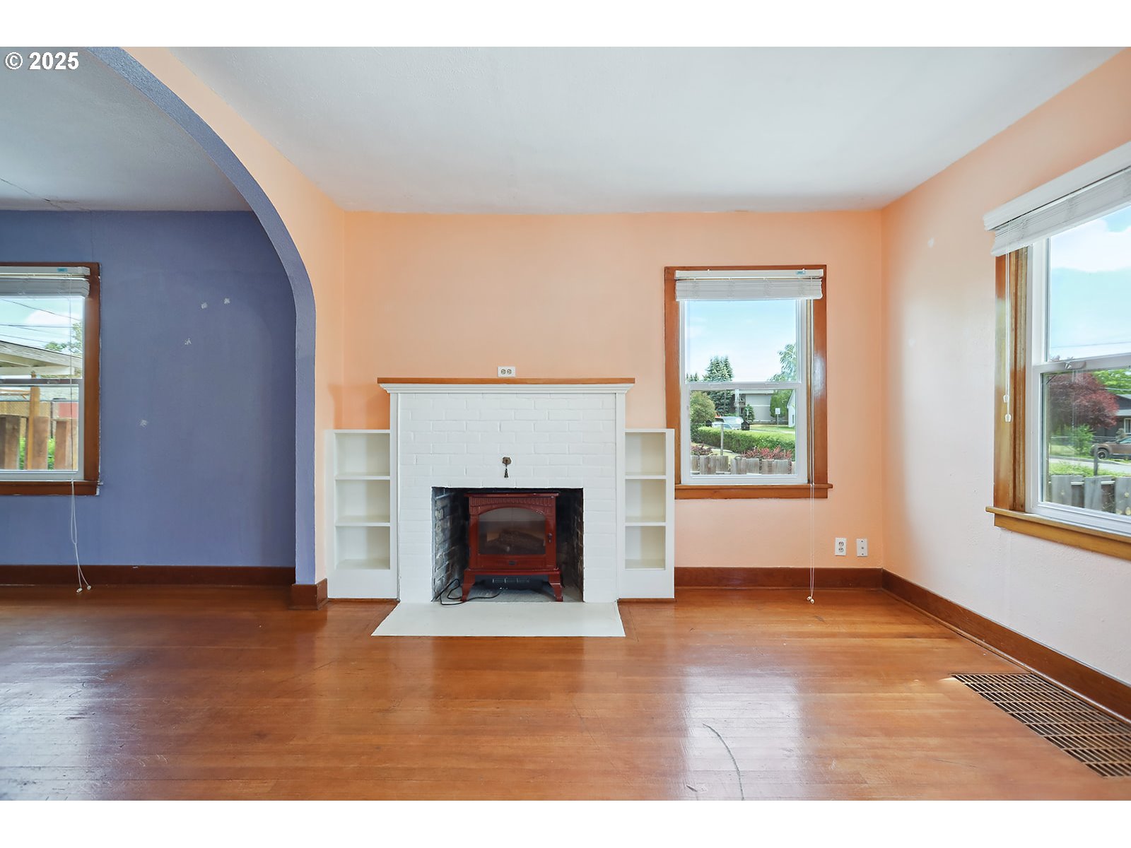 323 West Broadway Street Goldendale, WA 98620 - Photo 4 of 41 a view of an empty room with wooden floor fireplace and a window