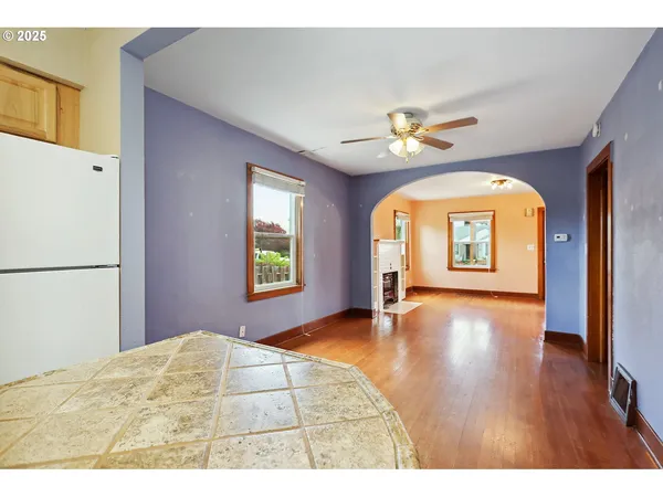 a view of an empty room with window and wooden floor