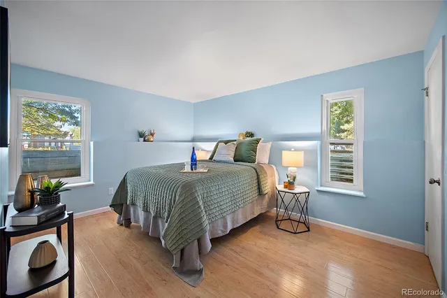a bedroom with a bed a table and a dresser next to a window