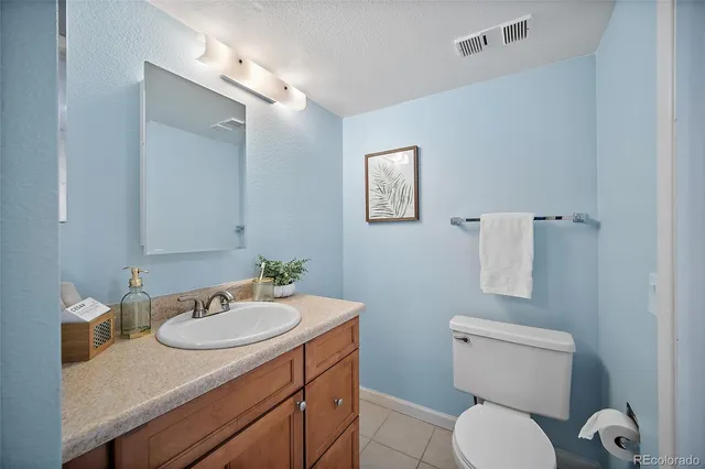 a bathroom with a granite countertop toilet sink and mirror
