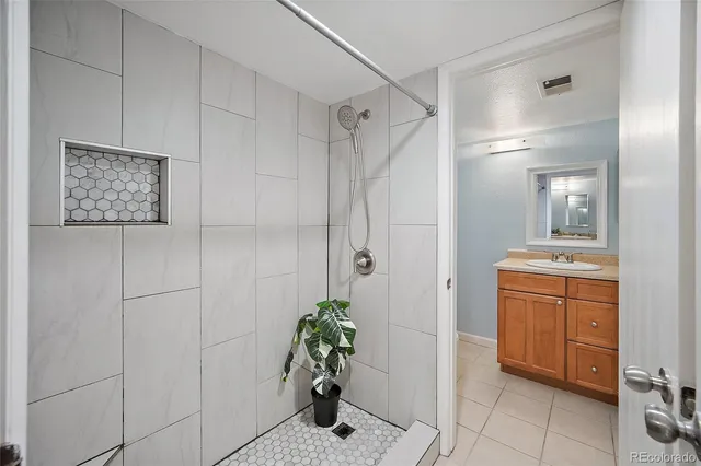 a bathroom with a granite countertop sink a mirror and a shower