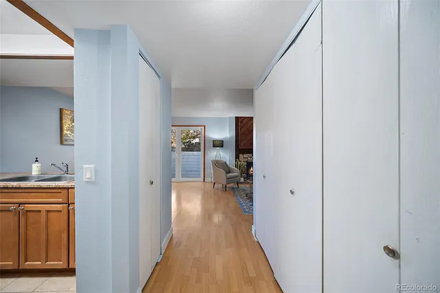 a view of a hallway with wooden floor and closet