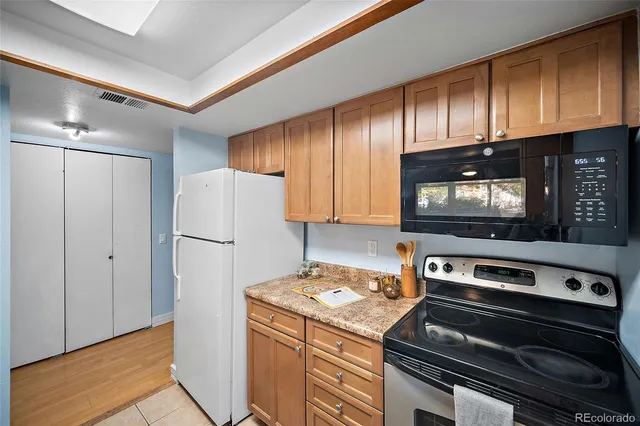 a kitchen with a refrigerator stove and cabinets
