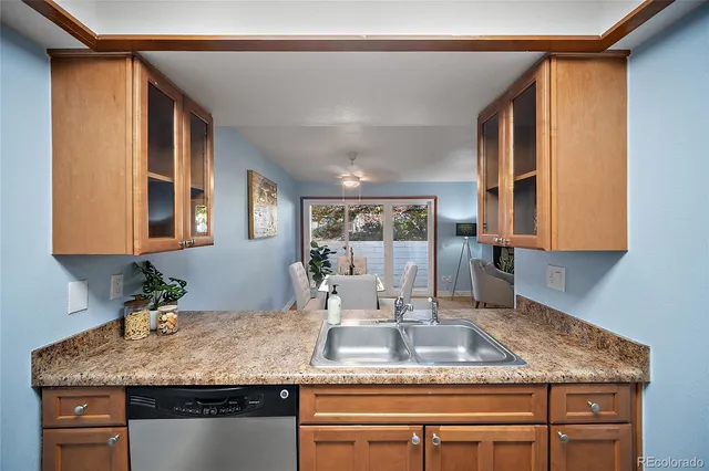 a kitchen with kitchen island granite countertop a sink and large window