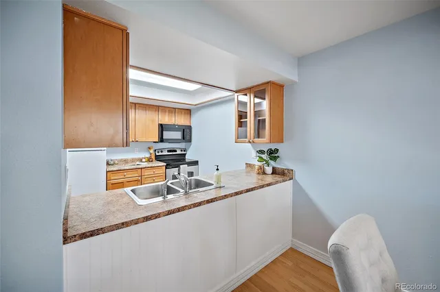 a kitchen with stainless steel appliances granite countertop a sink and a wooden cabinets