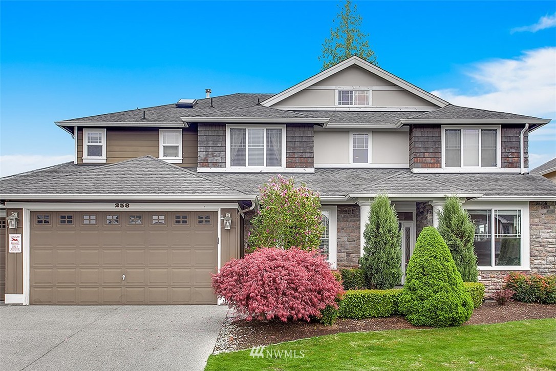 258 Lyons Place Northeast Renton, WA 98059 - Photo 2 of 25 a front view of a house with a garden and plants