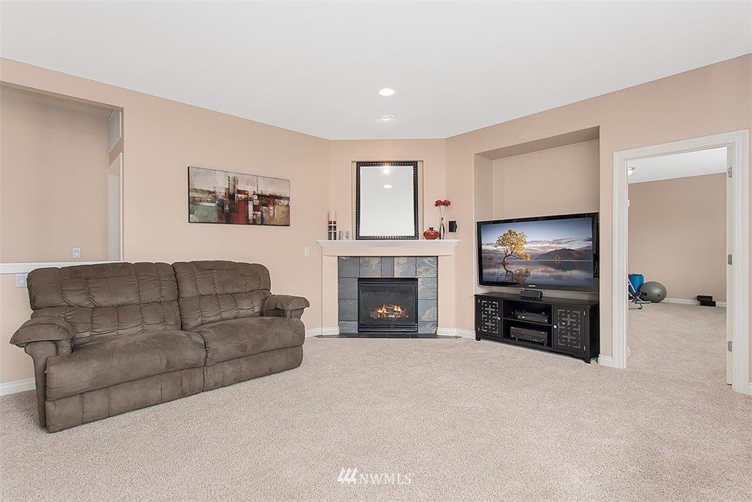258 Lyons Place Northeast Renton, WA 98059 - Photo 11 of 25 a living room with furniture a flat screen tv and a fireplace