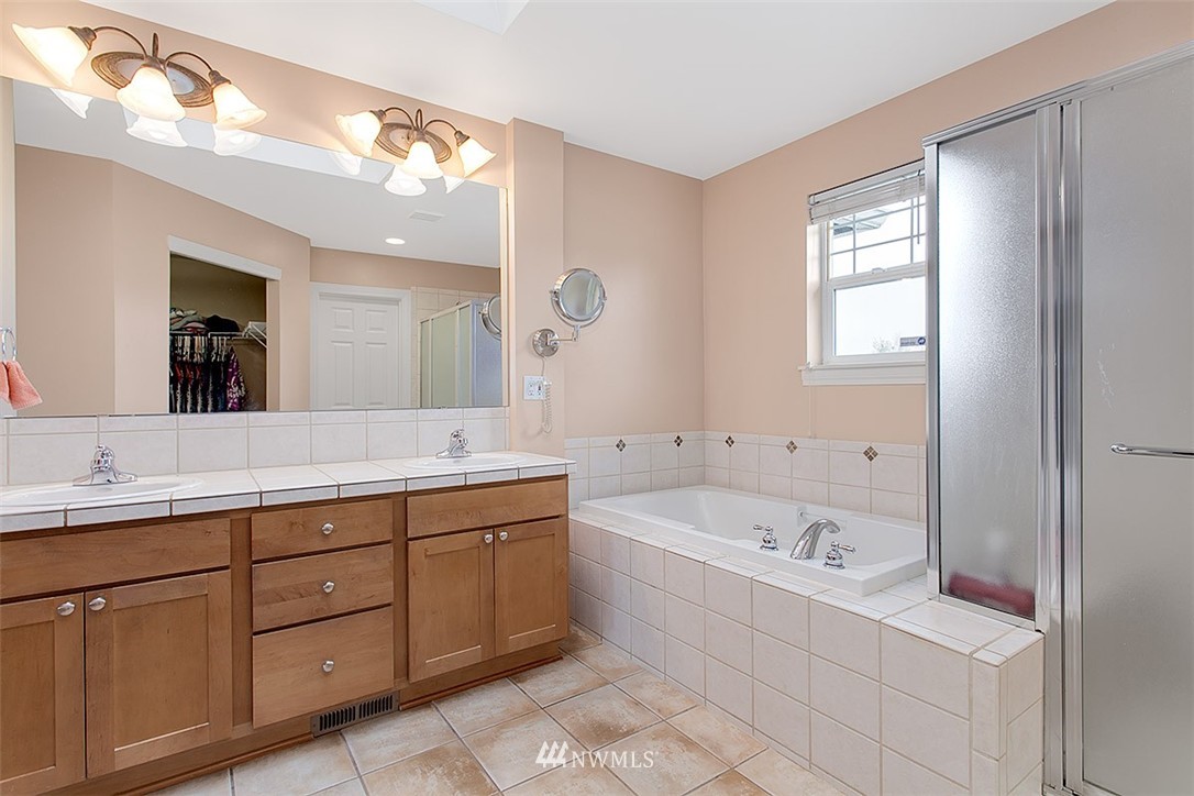 258 Lyons Place Northeast Renton, WA 98059 - Photo 19 of 25 a bathroom with a tub a sink and mirror
