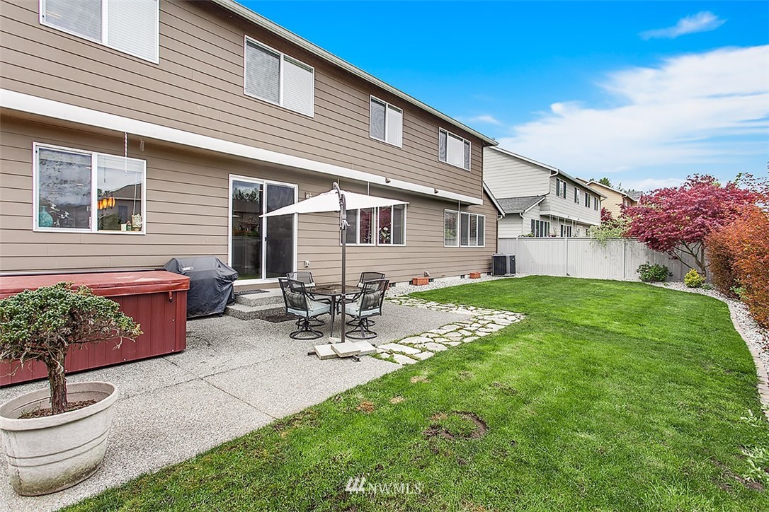 258 Lyons Place Northeast Renton, WA 98059 - Photo 24 of 25 a view of a patio with table and chairs potted plants and a large tree