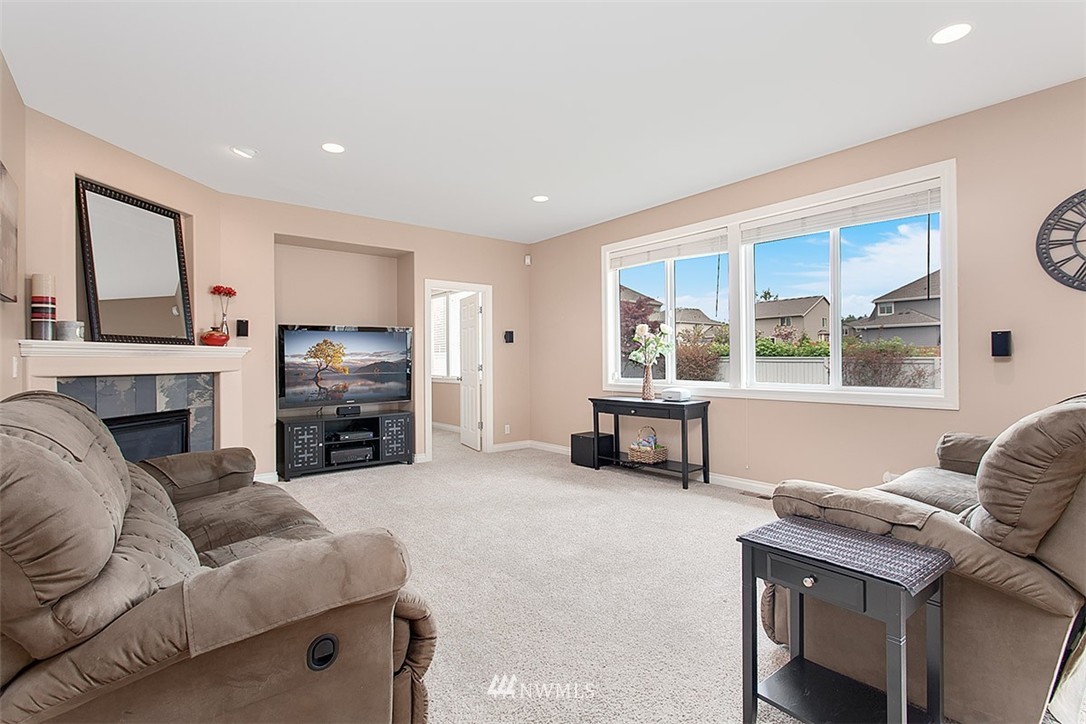 258 Lyons Place Northeast Renton, WA 98059 - Photo 10 of 25 a living room with furniture a fireplace and a large window
