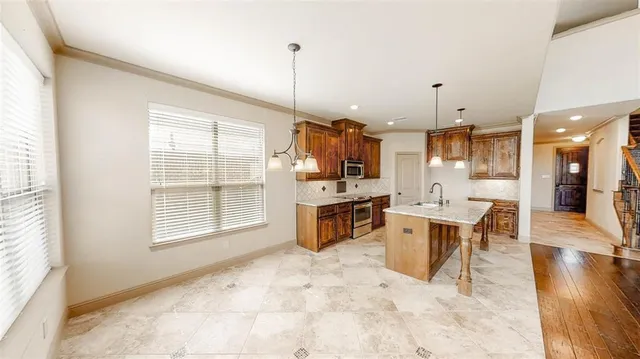 a kitchen with stainless steel appliances granite countertop a sink a stove and a refrigerator