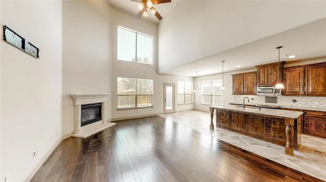 a large kitchen with cabinets wooden floor and a fireplace