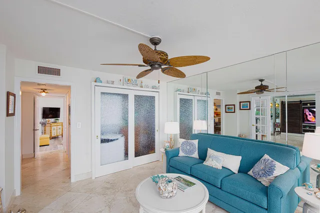 a living room with furniture kitchen view and a chandelier
