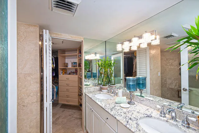 a bathroom with a granite countertop sink a mirror and a shower