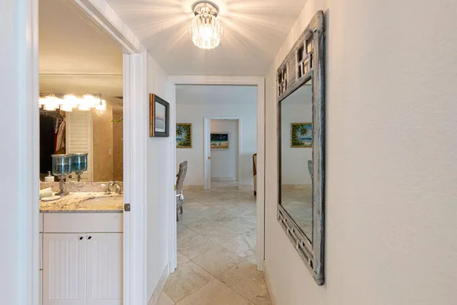 a view of a hallway with wooden floor and chandelier