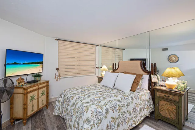 a bedroom with a bed and a flat screen tv
