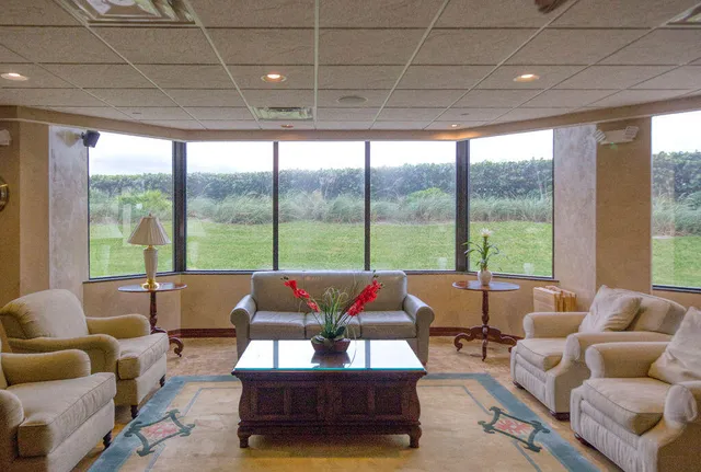 a living room with fireplace furniture and a large window
