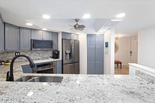 a kitchen with stainless steel appliances granite countertop a refrigerator and a sink