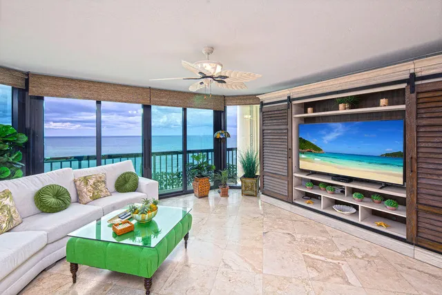 a living room with furniture a flat screen tv and a floor to ceiling window