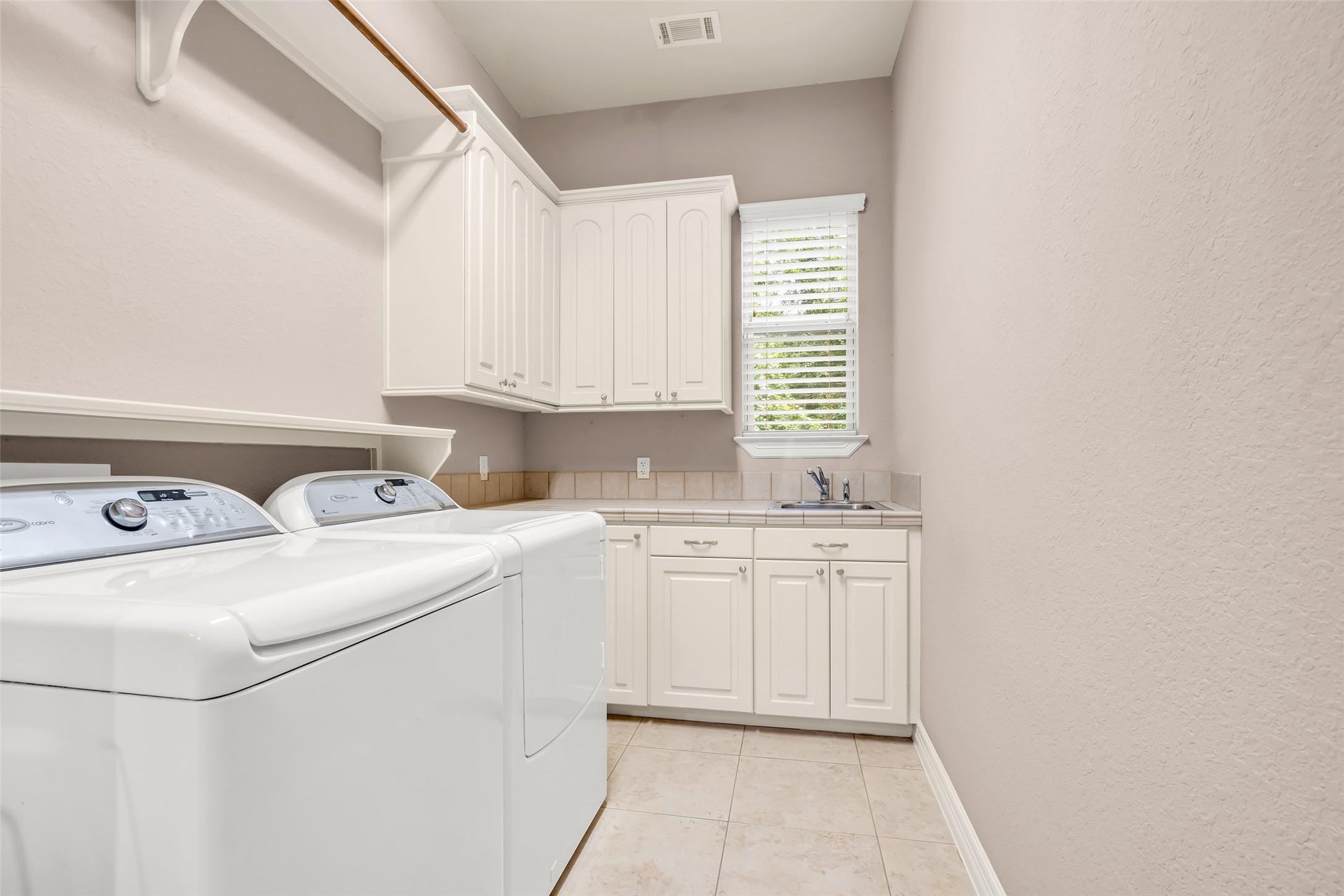 27434 Whispering Maple Way Spring, TX 77386 - Photo 16 of 41 Laundry room has tiled counter tops for folding. The extra refrigerator, washer and dryer are included