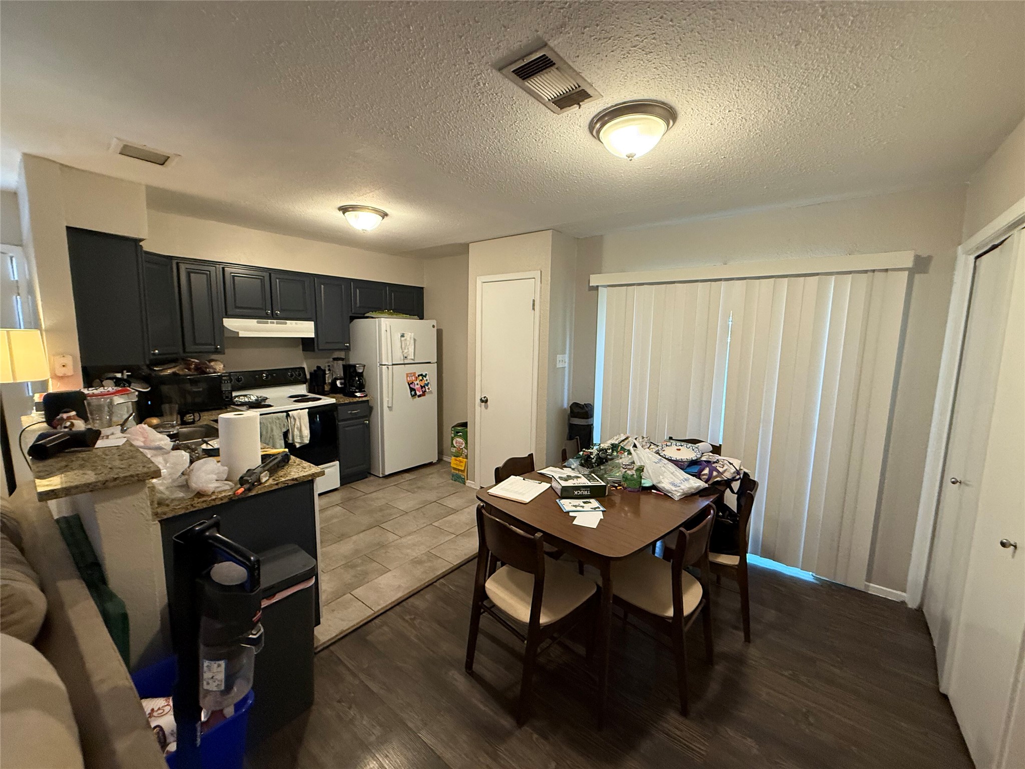 11905 Alpheus Avenue Austin, TX 78759 - Photo 2 of 23 a kitchen with a table chairs refrigerator and microwave