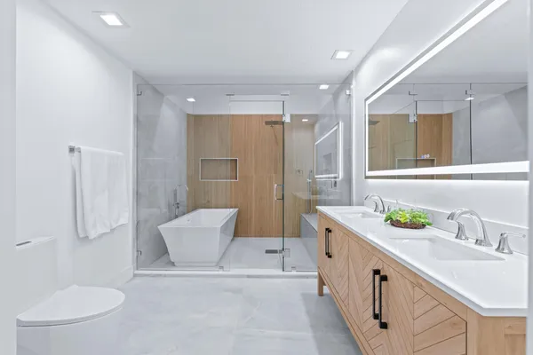 a spacious bathroom with a double vanity sink toilet and a mirror