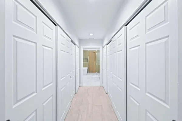 a view of a hallway with wooden floor and staircase
