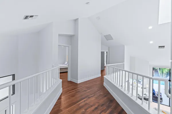 a view of a hallway with wooden floor and staircase