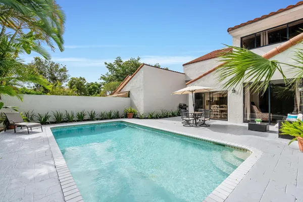 a view of house with swimming pool and sitting area