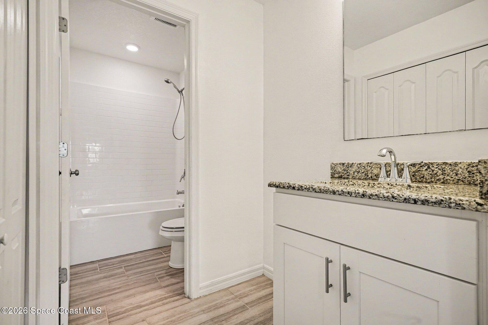 414 Hancock Street Palm Bay, FL 32908 - Photo 15 of 31 a bathroom with a granite countertop sink a toilet and shower