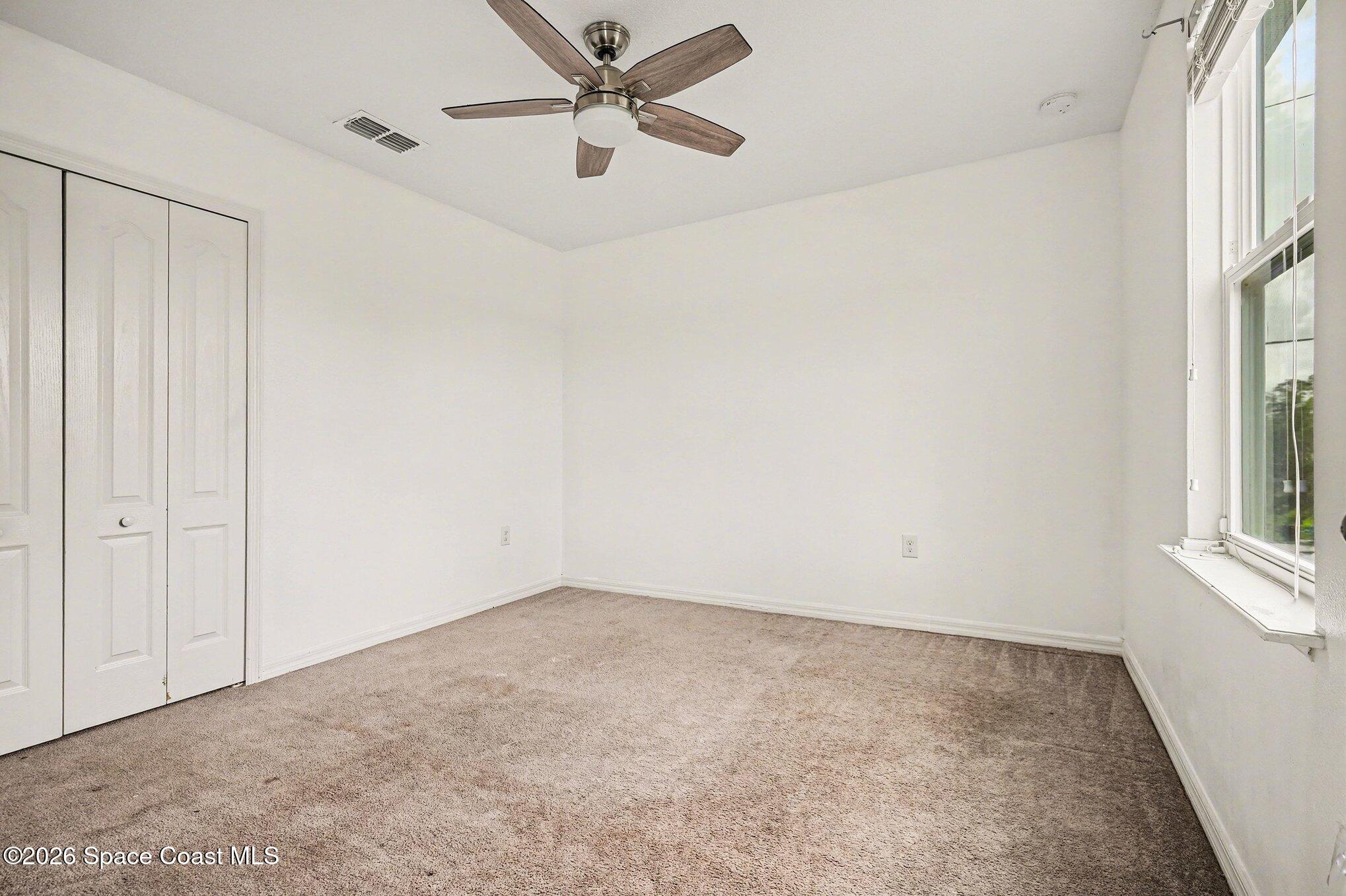 414 Hancock Street Palm Bay, FL 32908 - Photo 17 of 31 an empty room with windows and fan