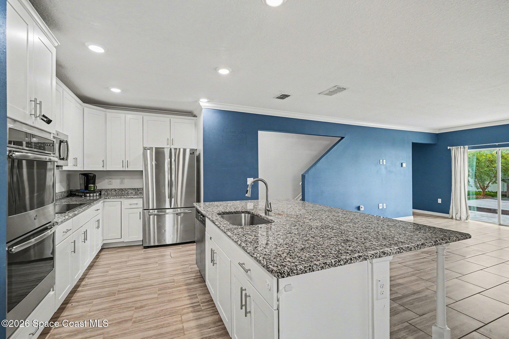 414 Hancock Street Palm Bay, FL 32908 - Photo 2 of 31 a kitchen with stainless steel appliances granite countertop a sink stove and refrigerator