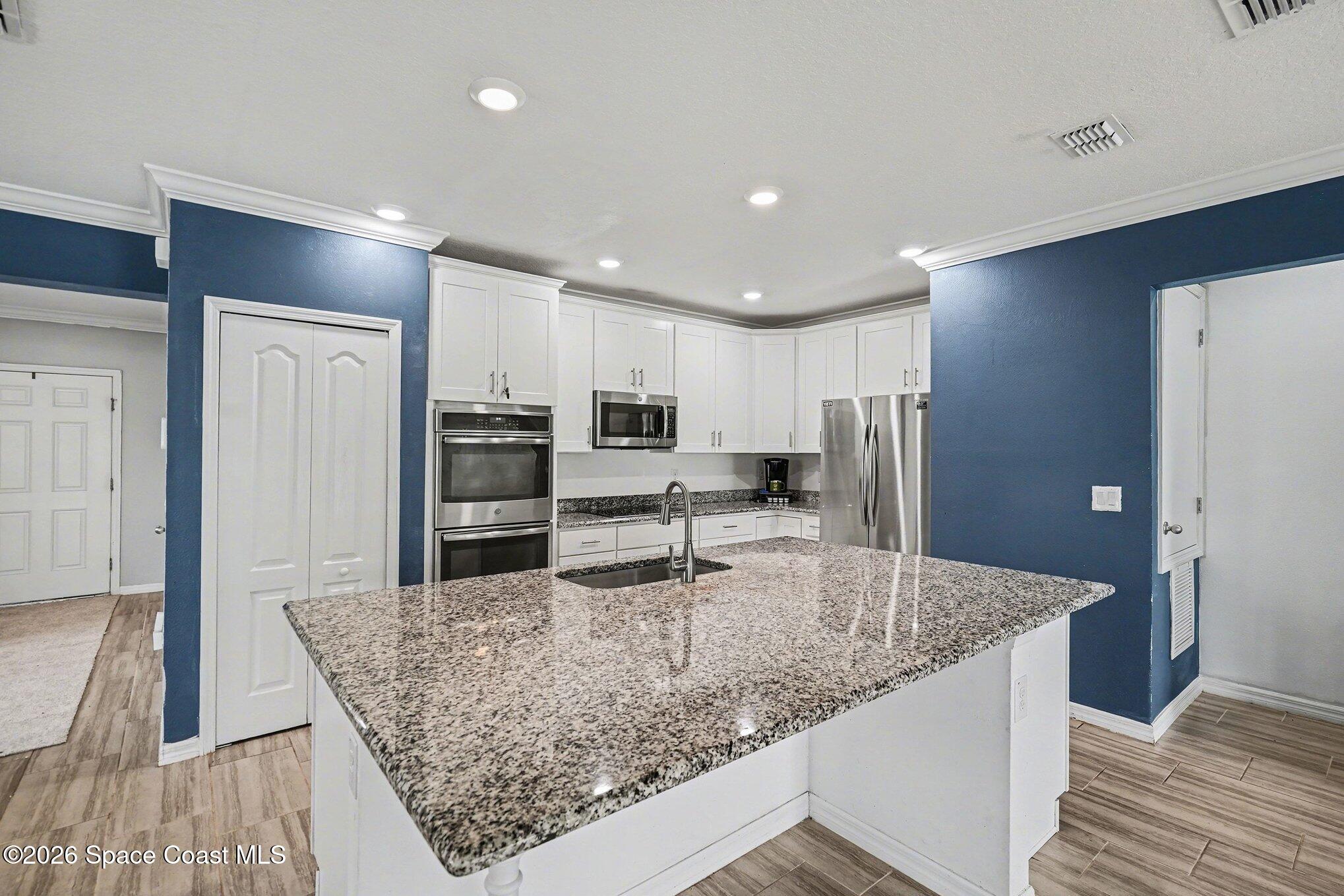 414 Hancock Street Palm Bay, FL 32908 - Photo 3 of 31 a kitchen with stainless steel appliances granite countertop a sink and a refrigerator
