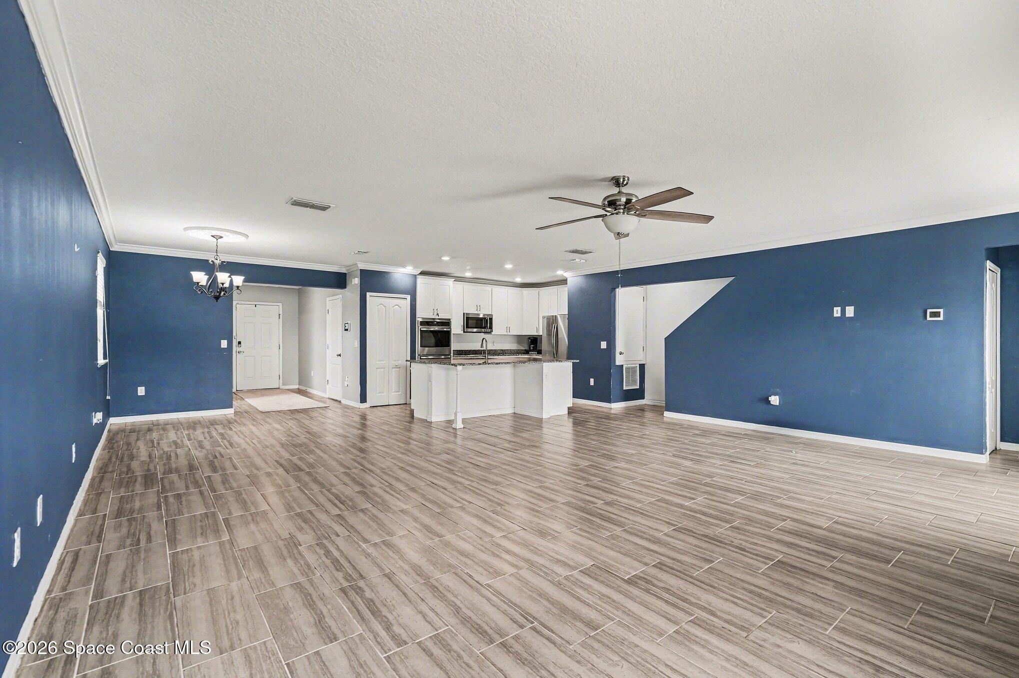414 Hancock Street Palm Bay, FL 32908 - Photo 4 of 31 a view of a livingroom with a ceiling fan and wooden floor