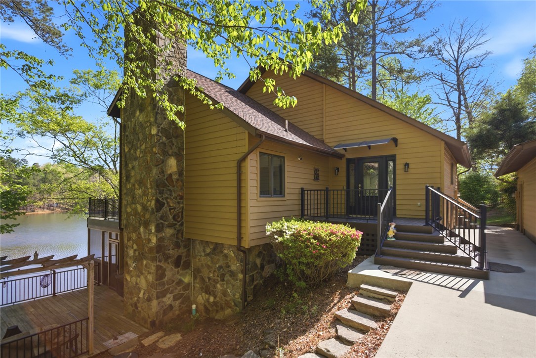 120 Farris Sandra Road West Union, SC 29696 - Photo 2 of 50 This captivating waterfront residence features a spacious deck and stone accents, offering serene lake views.