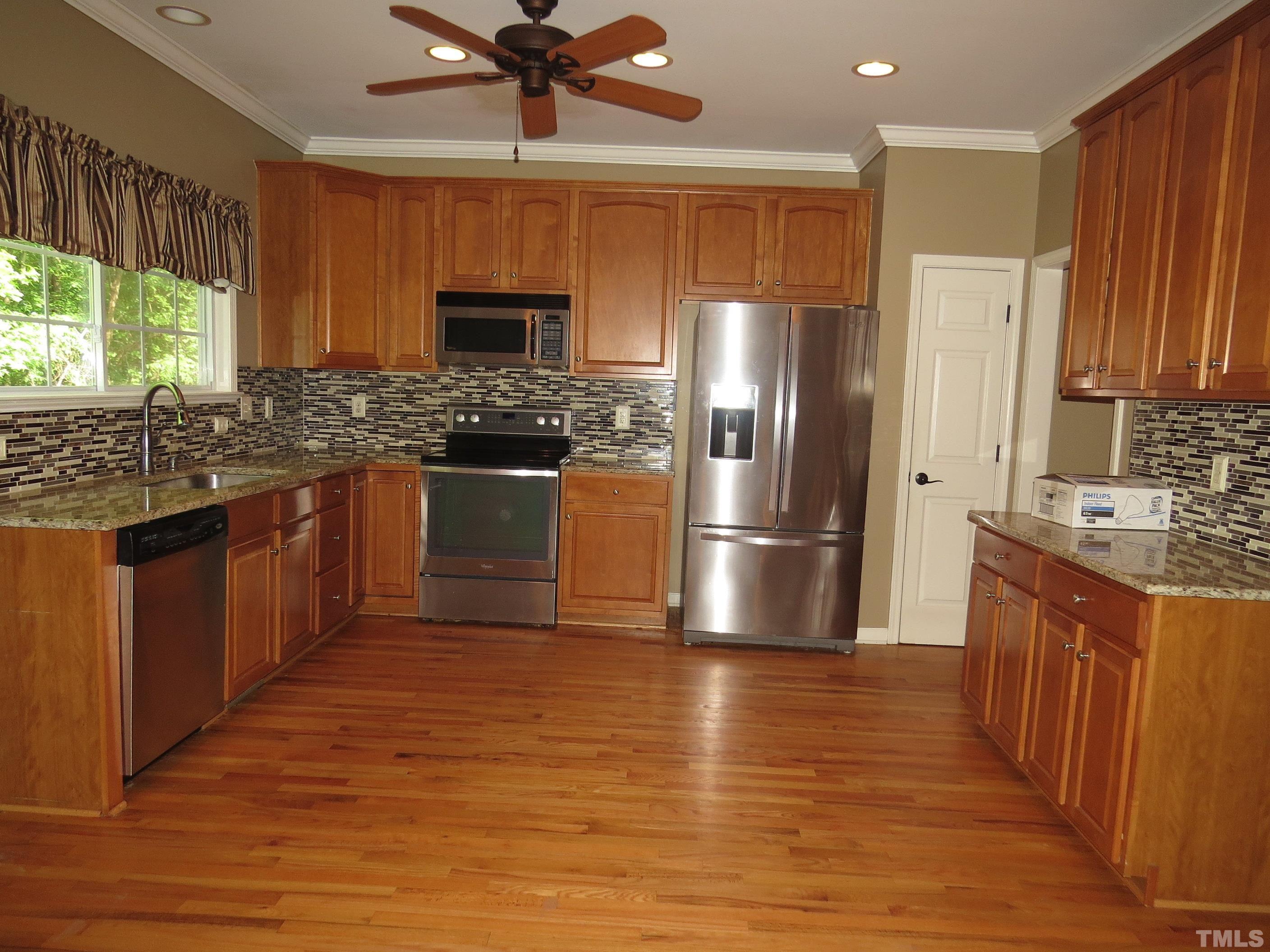 12202 Fox Valley Street Raleigh, NC 27614 - Photo 3 of 24 a kitchen with stainless steel appliances granite countertop a stove a sink dishwasher a refrigerator and a oven