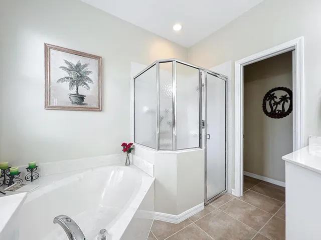a bathroom with a granite countertop sink a large mirror a bathtub and window