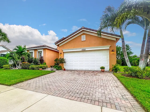 a front view of a house with a yard and potted plants