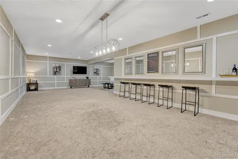 a large white kitchen with large windows and table