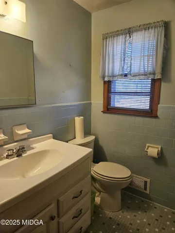 a bathroom with a sink a toilet and mirror