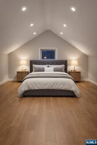 a spacious bedroom with a bed and a night stand