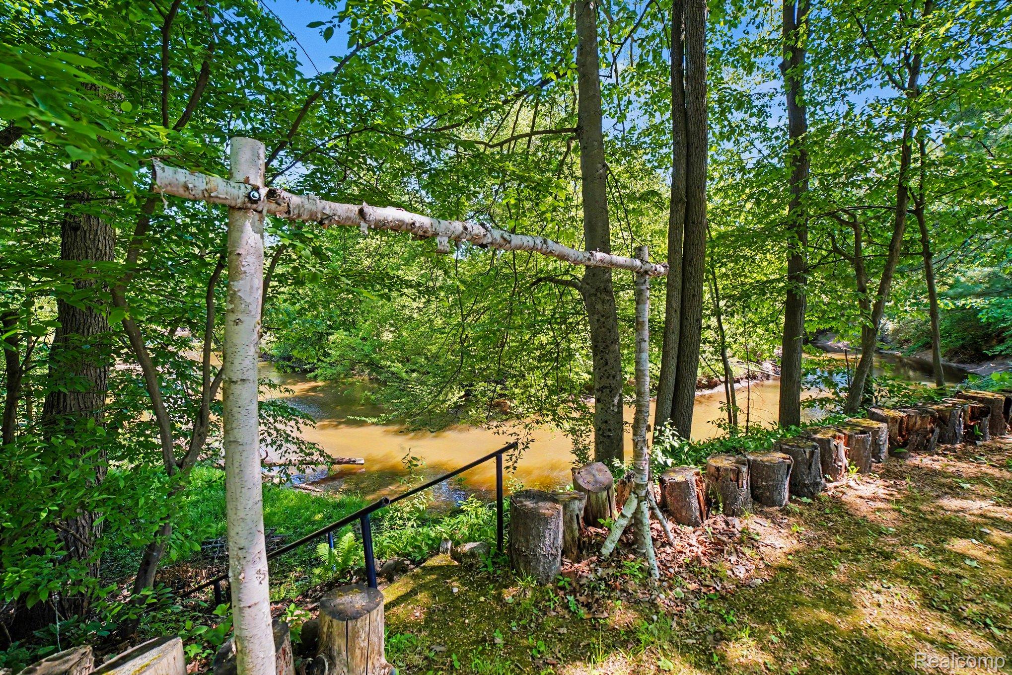 4772 South Bard Road Beaverton, MI 48612 - Photo 38 of 46 Wooded riverfront property featuring mature trees and a natural timber archway