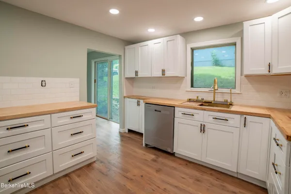 a kitchen with cabinets appliances and a wooden floor