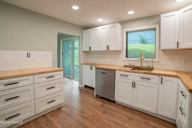 a kitchen with cabinets appliances and a wooden floor