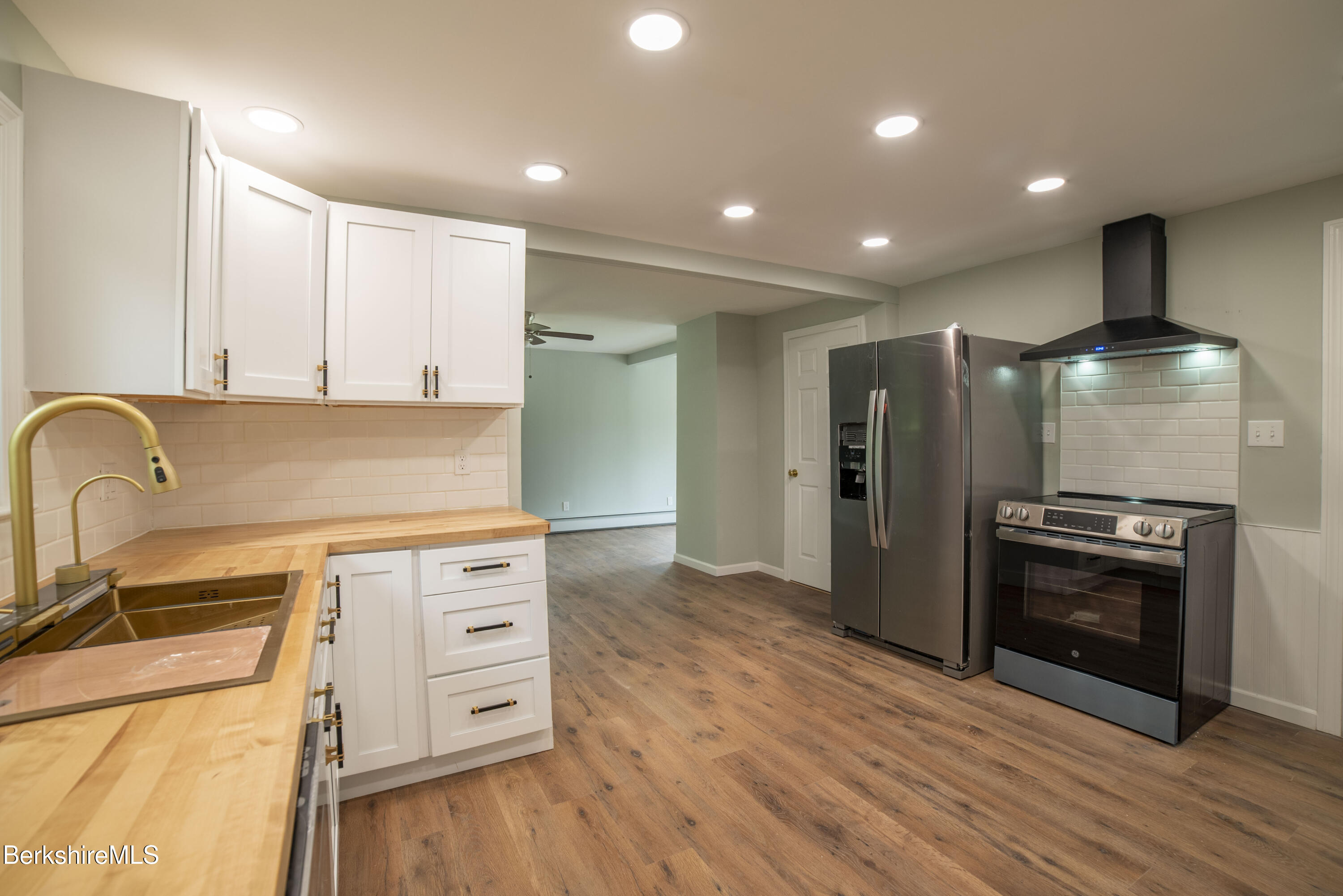 7 Hughes Street Adams, MA 01220 - Photo 4 of 22 a kitchen with stainless steel appliances granite countertop a refrigerator a stove and a wooden floors