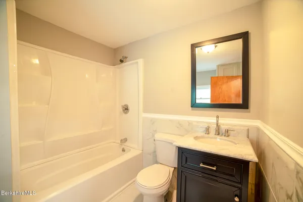a bathroom with a granite countertop sink toilet and shower