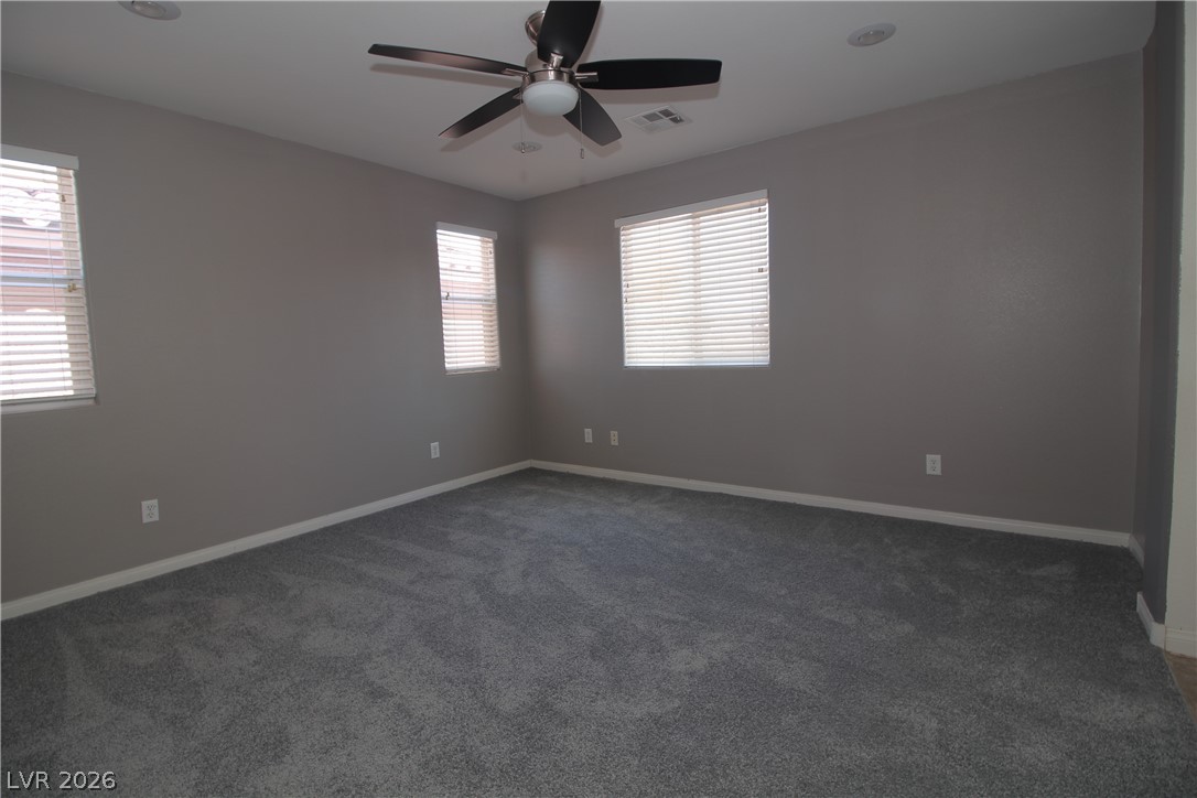 9289 Valley Ranch Avenue Las Vegas, NV 89178 - Photo 23 of 29 A spacious room with soft carpeting and ample natural illumination from multiple windows.