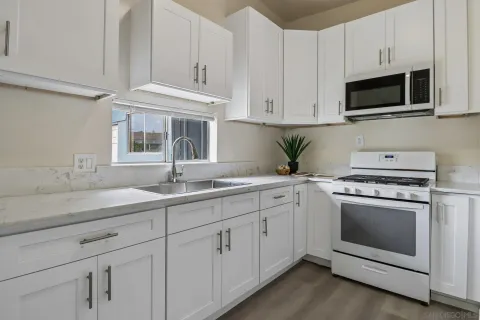 a kitchen with cabinets appliances and a sink
