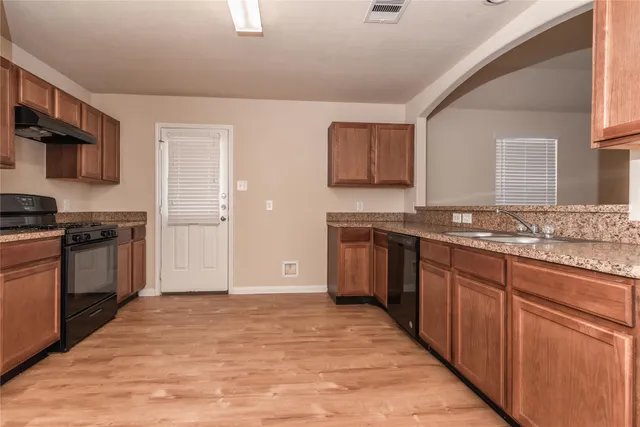 a kitchen with stainless steel appliances granite countertop a stove a sink and a refrigerator