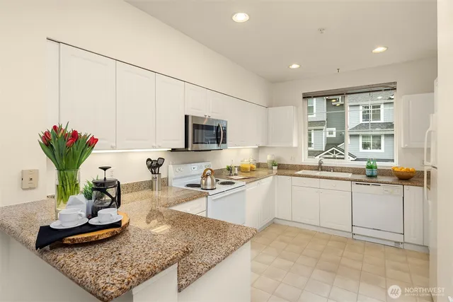 a kitchen with sink refrigerator and microwave